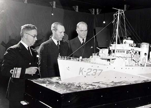 people_canada_nelles Rear-Admiral P.W. Nelles and Hon. Angus McDonald, Minister of National Defence for Naval Services, taking a look at the model of a corvette at Naval Exhibition, December 1942.