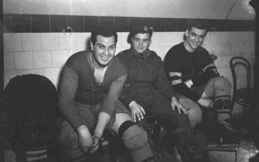 Three Canadian hockey players sit in their locker room in 1945