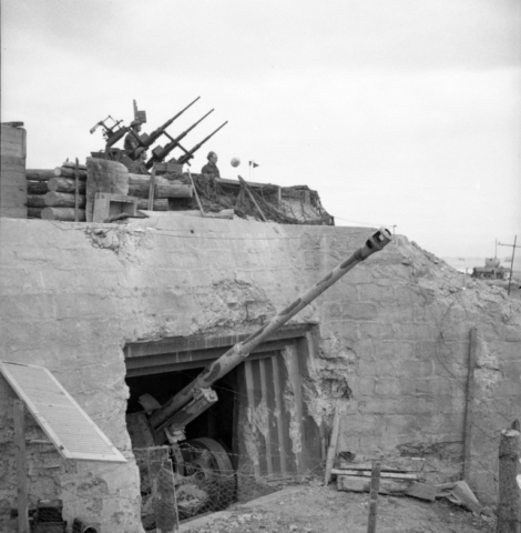 A German bunker at the entrance to the Courseulles-sur-Mer harbour has been transformed by the Canadians into a light anti-aircraft position, 14 July 1944. This bunker, which contains an 88 mm gun, was captured by the Regina Rifles on D-Day. Source: Canada. Dept. of National Defence / Library and Archives Canada / PA-140856 / Courtesy of the Juno Beach Centre Association Black and white photograph. A German bunker at the entrance to the Courseulles-sur-Mer harbour has been transformed by the Canadians into a light anti-aircraft position, 14 July 1944. This bunker, which contains an 88 mm gun, was captured by the Regina Rifles on D-Day. Source: Canada. Dept. of National Defence / Library and Archives Canada / PA-140856 / Courtesy of the Juno Beach Centre Association
